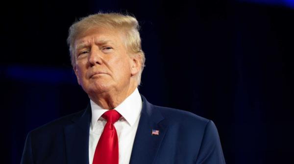 Do<em></em>nald Trump blue suit looking to side black background