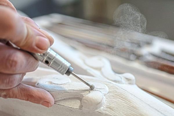 An ornamenatalist carves a detail of a new marble spire.