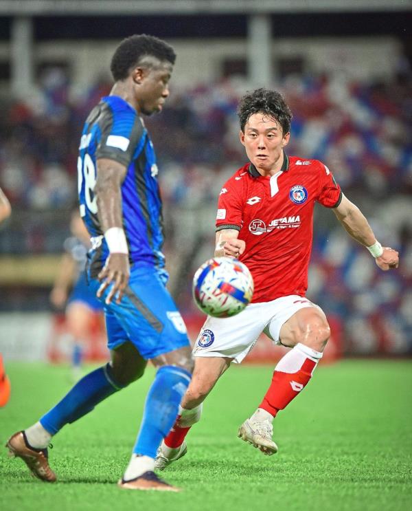 On guard: Sabah’s Ko Kwang-min (right) pressing a Kuching City player. — Bernama