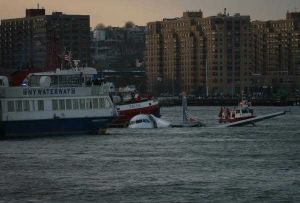  A US Airways jetliner struck a flock of geese is accompanied by emergency craft and a civilian ferry after an emergency landing in the Hudson River in New York. — ?2024 New York Times Company