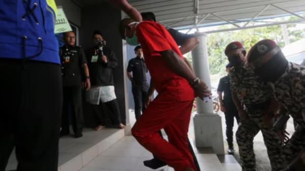 Mohd Affendi Awang, a 42-year-old father of five is escorted by a prison guard to face a public caning at a mosque, after being repeatedly co<em></em>nvicted of the Islamic crime of 'khalwat', or close proximity between unmarried couples, at Kuala Terengganu, Malaysia December 27, 2024. REUTERS/Stringer