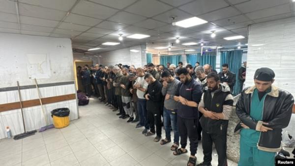 People pray next to the dead bodies of Palestinians at Kamal Adwan Hospital, during the Israeli military operation, amid Israel-Hamas conflict, in Beit Lahiya, in the northern Gaza Strip, Dec. 17, 2024.