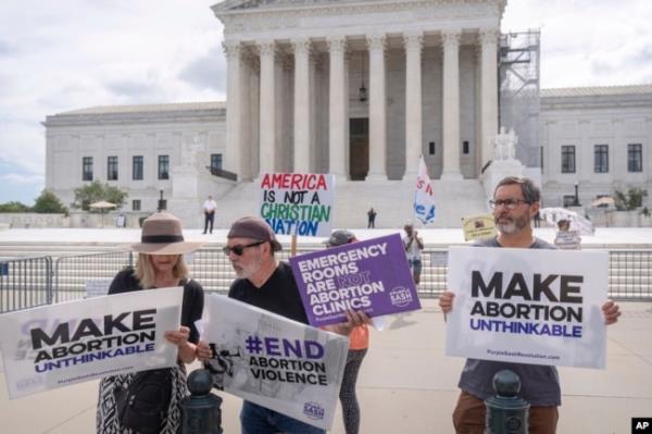 FILE - Katie Mahoney, left, and the Rev. Patrick Mahoney, chief strategy officer for Stanton Healthcare, an Idaho-ba<em></em>sed pregnancy center that does not provide abortions, read the text of a Supreme Court decision outside the court in Washington, June 27, 2024.
