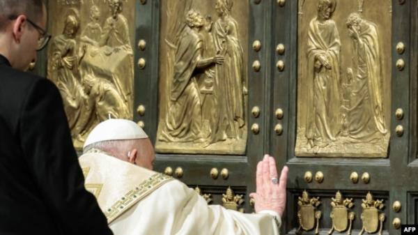 Pope Francis (R) opens the Holy Door of St Peter's Basilica, during a special ceremony to mark the launch of the Jubilee 2025, a year of Catholic celebrations set to draw more than 30 million pilgrims to Rome, at the Vatican, on Dec. 24, 2024.