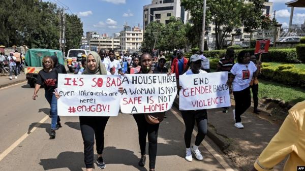 FILE - Protesters carry banners and chant slogans as they march through Eldoret, western Kenya, , to demo<em></em>nstrate against the murder of women in Kenya, on Sept. 13, 2024.