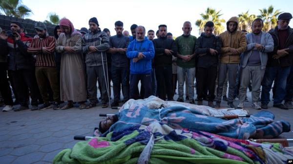 Palestinians pray next to the bodies of their relatives killed in the Israeli bombardment of the Gaza Strip at Al-Aqsa Hospital in Deir al-Balah, Dec. 19, 2024.