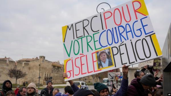 A man holds a placard reading 'Thank you for your courage Gisele Pelicot' outside the Avignon courthouse, southern France, Dec. 19, 2024. 