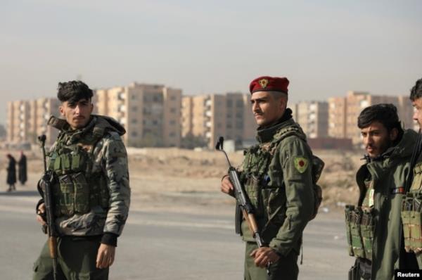 Members of Kurdish-led Syrian Democratic Forces (SDF) stand along a street, after rebels seized the capital and ousted Syria's Bashar al-Assad, in Hasakah, Syria, Dec. 11, 2024.
