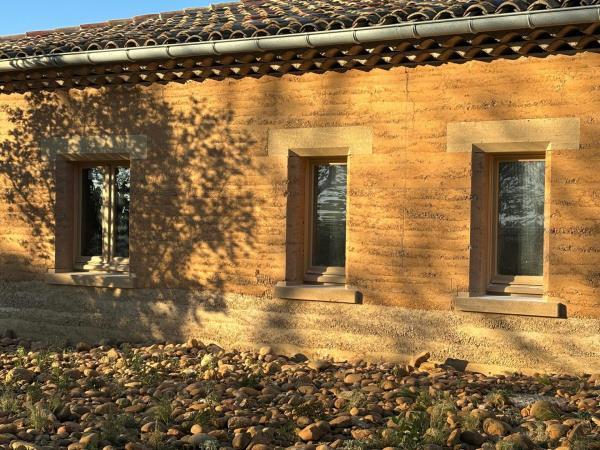 close up of building with orange walls made of compacted earth