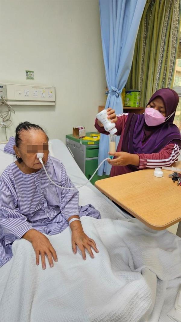 A family member helps a patient who is unable to eat, with parenteral nutrition, or tube feeding, to optimise her nutrition before surgery. — Photos: Dr OOI WEI KEAT