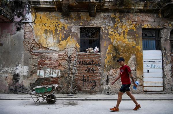 More than a year ago, a simple and forceful graffiti that reads 'You need to be happy' began to appear on the worn walls of Havana. The seemingly innocent message has become an echo of reflection for many and an inspiration for young Cuban creators. Photo: AFP 