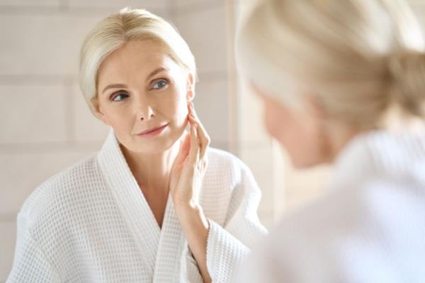 woman looking at face in mirror