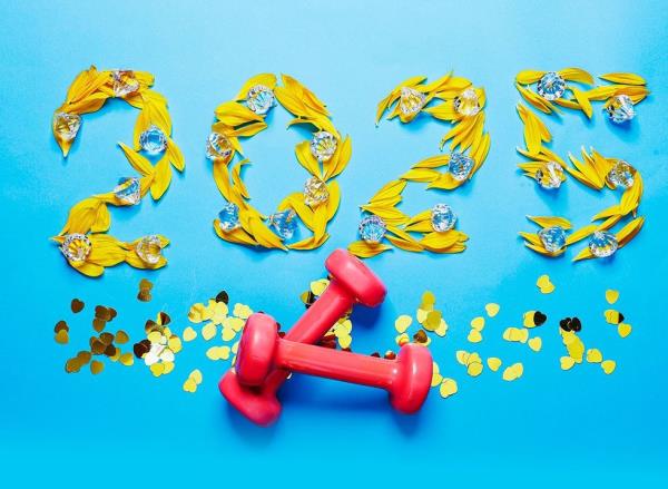 2025 written in flower petals and co<em></em>nfetti with a pair of hand weights in the foreground