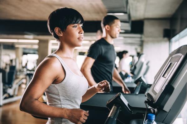 A woman on the treadmill at the gym looking out the window