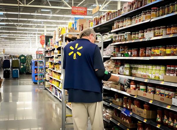 A Walmart employee stocks shelves in a store