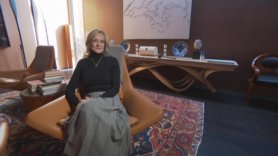 A woman sits in a chair.