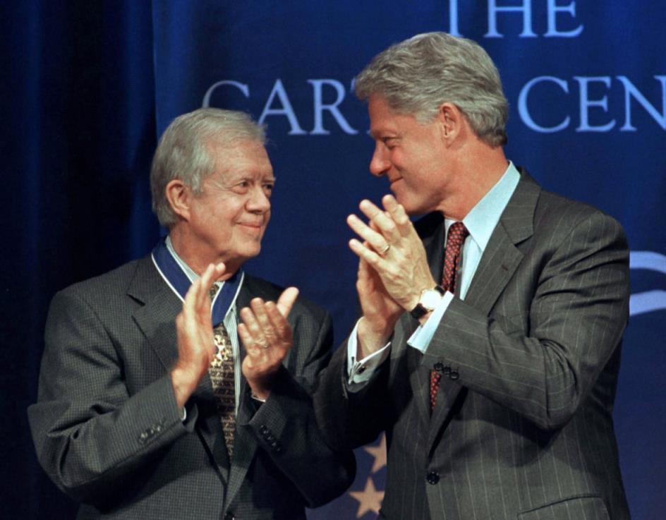 Two people look at each other while clapping.