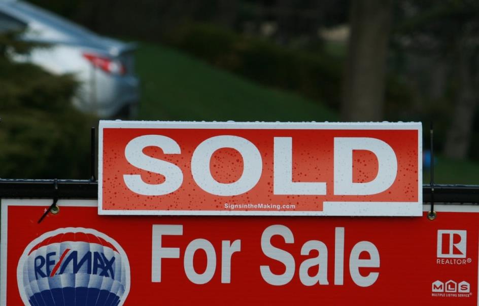 A sign that says Real Estate for Sale with a Sold bar on top of it.