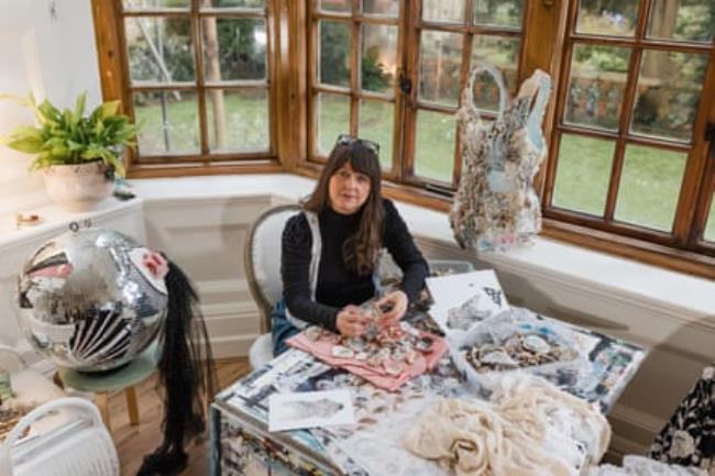 Nathalie Frost sitting by a window at a table spread with shells
