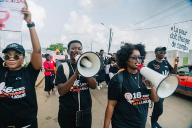 People march wearing matching campaign T-shorts and holding megaphones