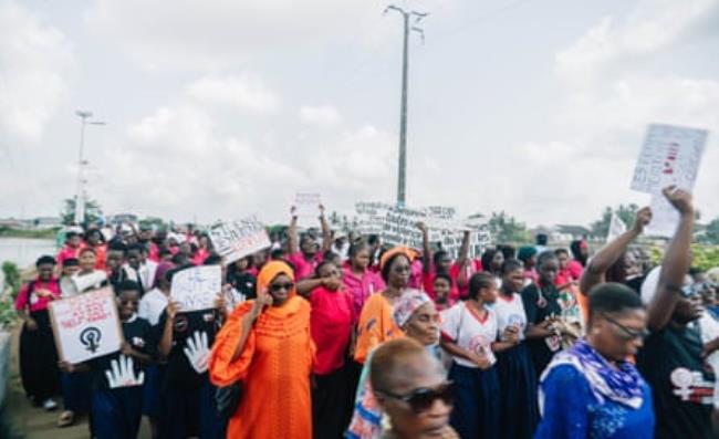 A crowd holding banners and placards written with slogans against rape, sexual violence and femicide