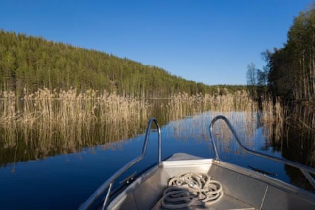 A boat sailing into an inlet on a lake