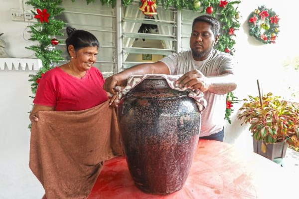 Savage (left) is pleased that her son Hendricks is gradually learning the art of crafting their traditio<em></em>nal homemade wine. 