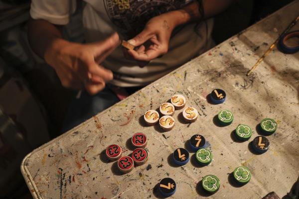 Dana Lopez sands a wooden token for poleana, a board game invented in prison, in his workshop in Mexico State. Photo: AP