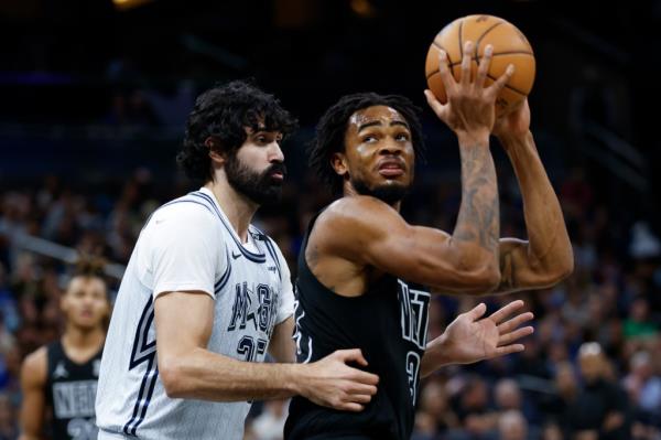 Orlando Magic center Goga Bitadze, front left, defends against Brooklyn Nets center Nic Claxton, right. 