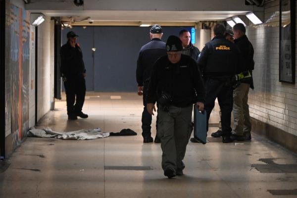 A photo showing officers from the NYPD searching the secluded tunnel for clues after a man was found on fire.