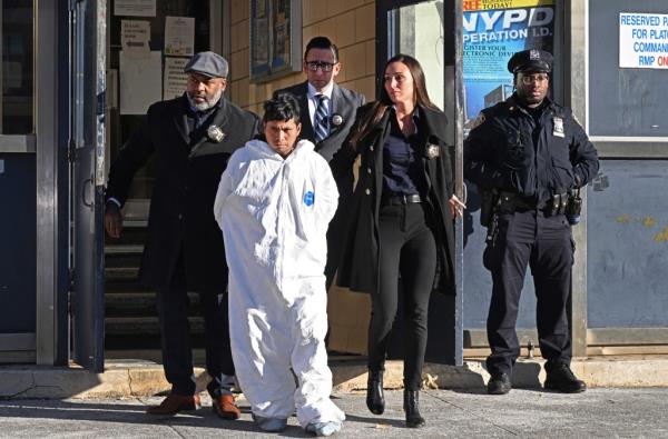 Sebastian Zapeta - Calil in a white jumpsuit, being escorted from the 60th Precinct towards court in Brooklyn, New York.