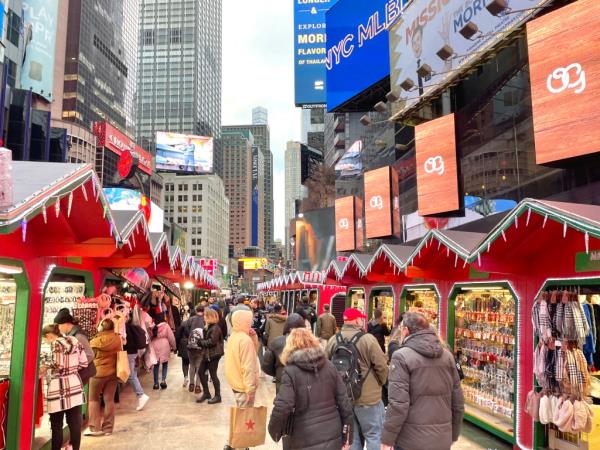 Crowds walk through a pop-up Holiday market located in Times Square