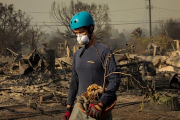 Man with green helmet and mask holds object