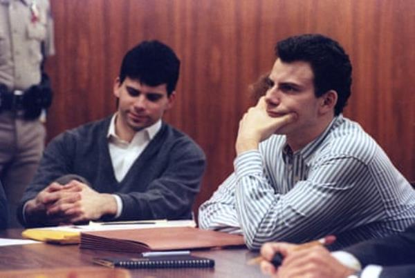 two men sitting together in a court room