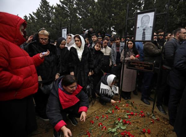 People mourn at the grave of the captain of the plane Igor Kshnyakin during the funeral of crew members of Azerbaijan Airlines Flight J2-8243 that crashed near Aktau, in Baku, Azerbaijan December 29, 2024. (Reuters)