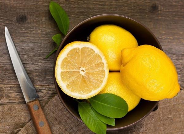 A bowl of lemons on a wooden table