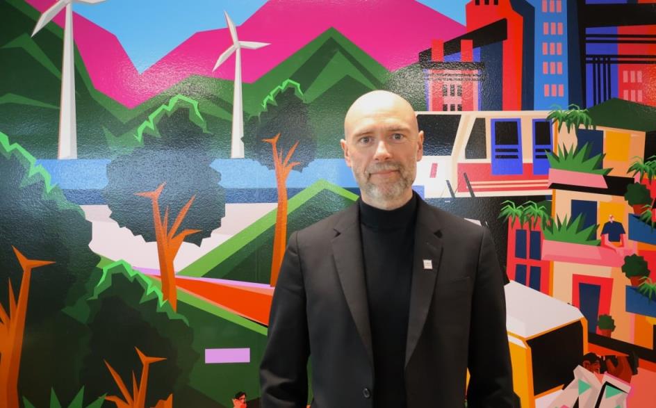 Man standing in front of a mural.