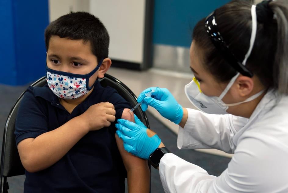 A child receives a vaccine from a nurse.