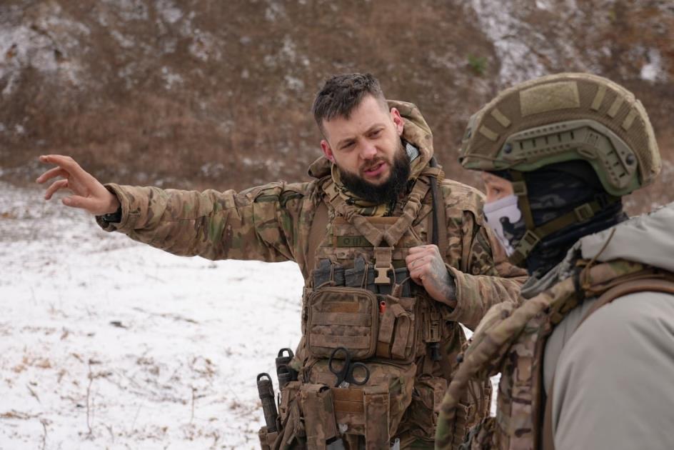 One soldier explains a training exercise to another soldier
