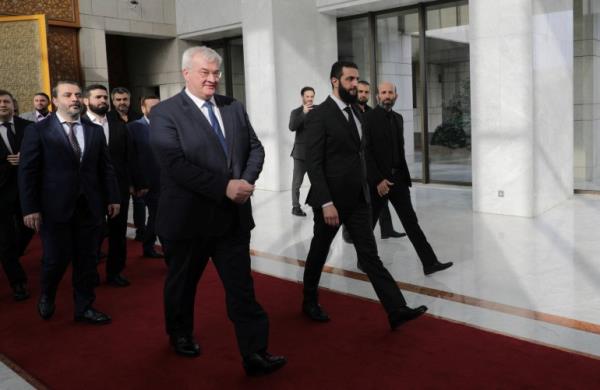Syria's de facto leader Ahmed al-Sharaa, also known as Abu Mohammed al-Golani walks as he meets with senior Ukrainian delegation led by Ukrainian Foreign Minister Andrii Sybiha