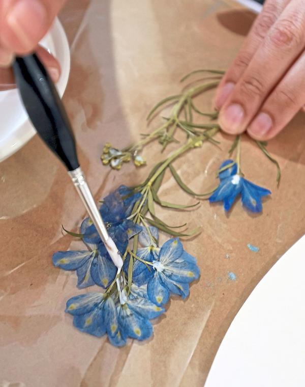 With steady hands and a keen eye for detail, Netalia Zerina patiently glues the delicate flowers before attaching them to paper.